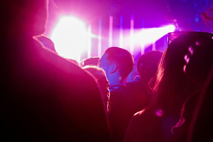man and woman kissing in front of stage